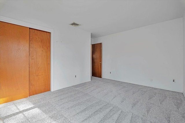 unfurnished bedroom featuring carpet floors and a closet