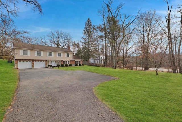 raised ranch featuring a garage and a front yard