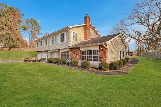 back of house with a garage and a lawn