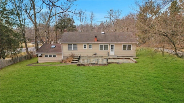 back of property featuring a wooden deck and a lawn