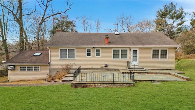 back of house with a deck and a yard