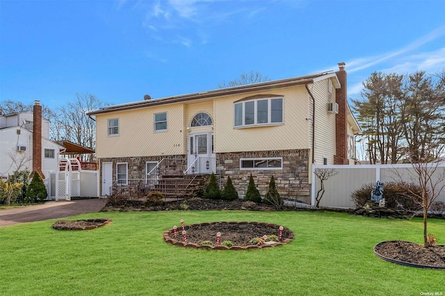 bi-level home with a garage and a front lawn