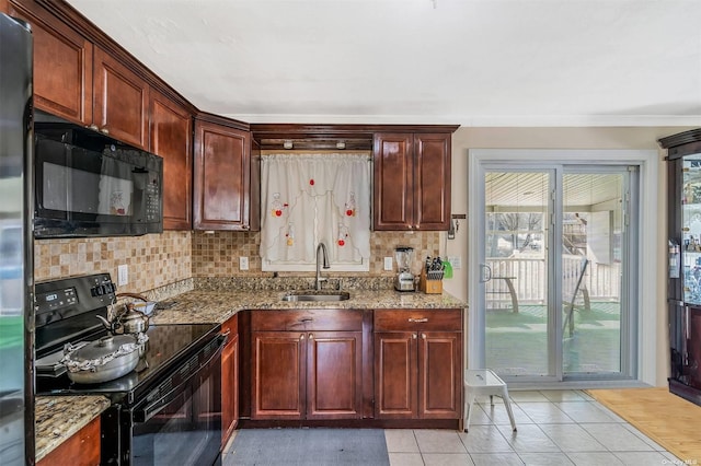 kitchen featuring tasteful backsplash, light stone countertops, sink, and black appliances