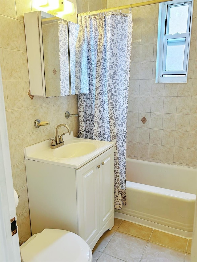 full bathroom featuring tile patterned floors, vanity, tile walls, toilet, and shower / tub combo with curtain