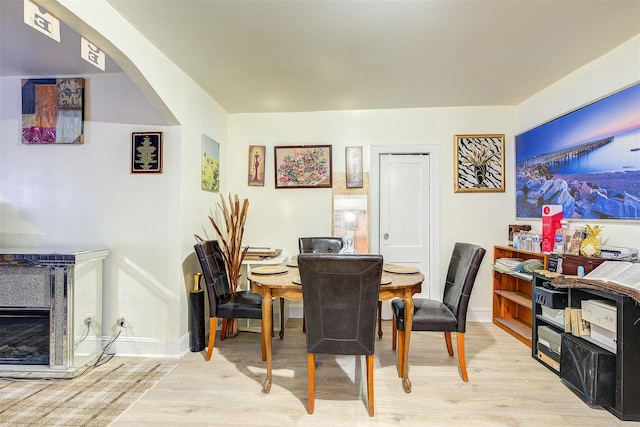 dining area with light hardwood / wood-style flooring and a fireplace