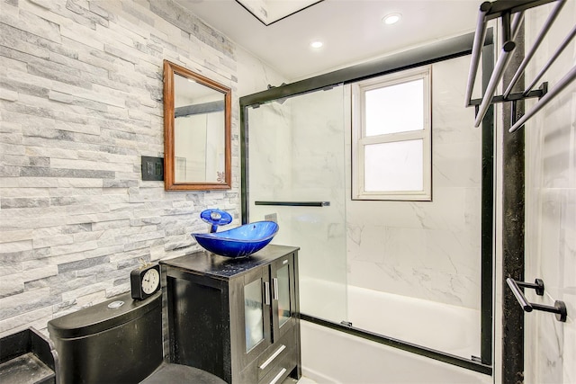 full bathroom with toilet, vanity, and shower / bath combination with glass door