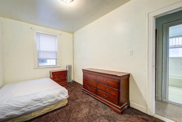 bedroom featuring dark carpet, radiator heating unit, and lofted ceiling