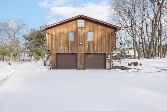 view of snow covered exterior featuring a garage