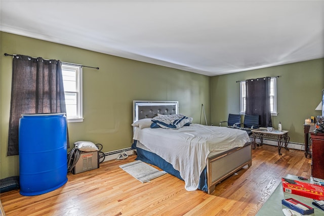 bedroom with light wood-type flooring and baseboard heating