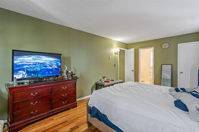 bedroom featuring connected bathroom and light hardwood / wood-style floors