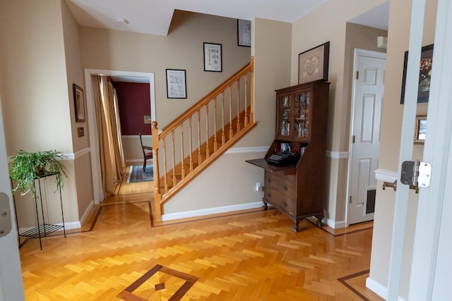 entrance foyer with stairs and baseboards