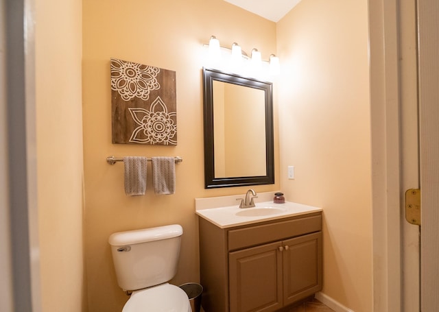 bathroom featuring vanity, toilet, and baseboards