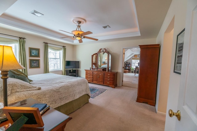 bedroom featuring light carpet, visible vents, a raised ceiling, and ceiling fan