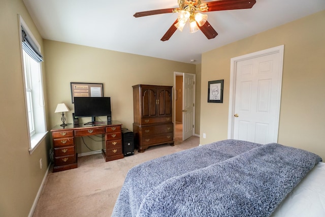 bedroom with light colored carpet, baseboards, and ceiling fan