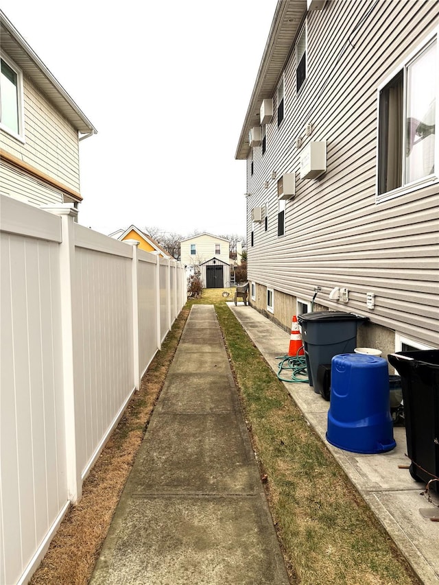 view of yard with a storage shed and a wall mounted air conditioner