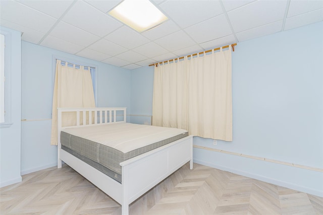 bedroom featuring light parquet flooring and a paneled ceiling