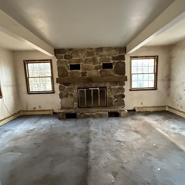 unfurnished living room featuring plenty of natural light, a baseboard heating unit, a stone fireplace, and concrete flooring