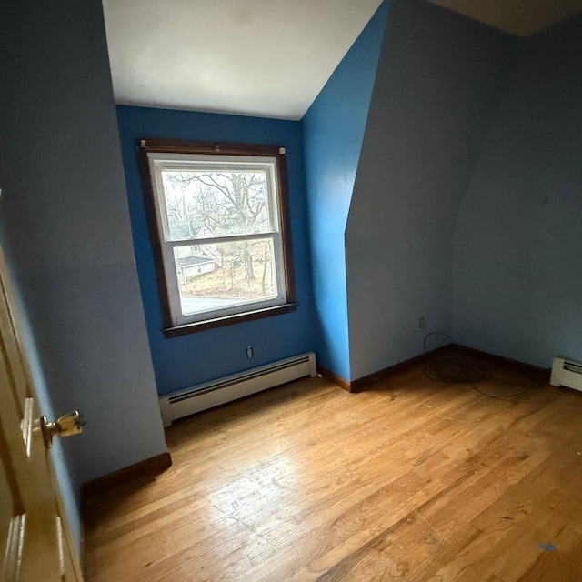 bonus room featuring vaulted ceiling, baseboard heating, and light hardwood / wood-style flooring