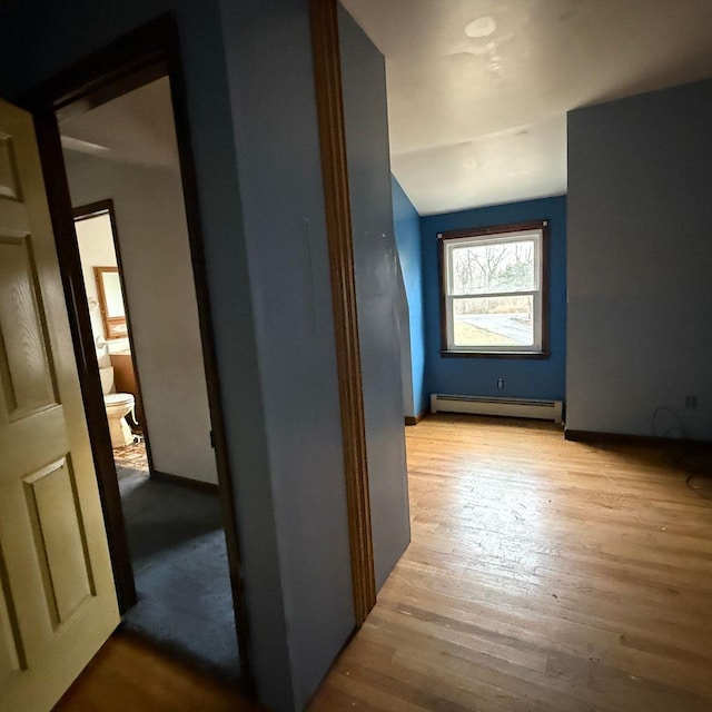 bonus room featuring a baseboard heating unit and light wood-type flooring