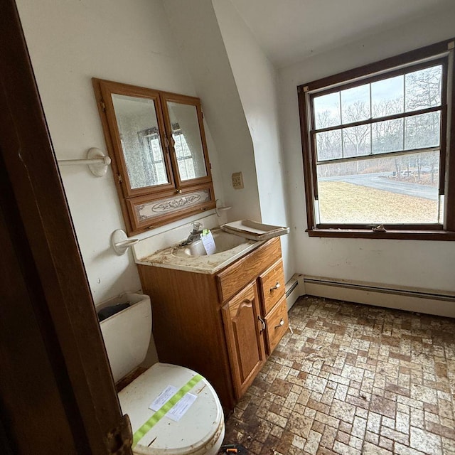 bathroom with a baseboard heating unit, toilet, and vanity