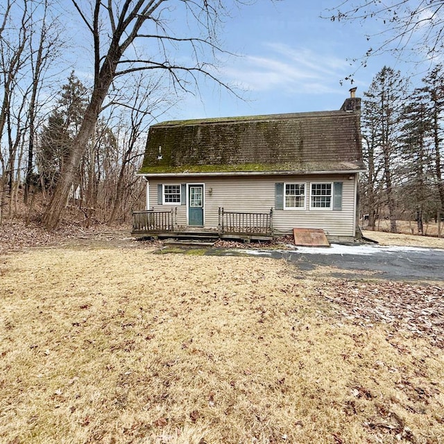 view of front of house featuring a wooden deck and a front yard