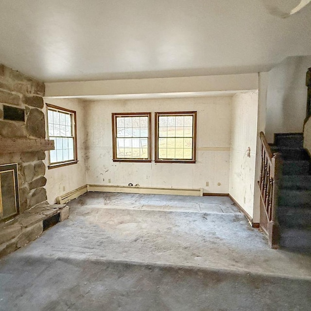 unfurnished living room with a fireplace and concrete flooring