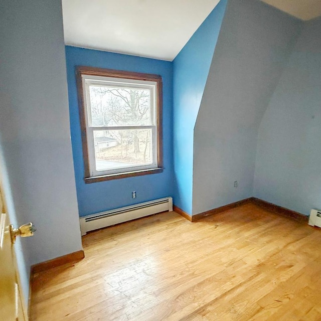 additional living space featuring a baseboard heating unit and light wood-type flooring