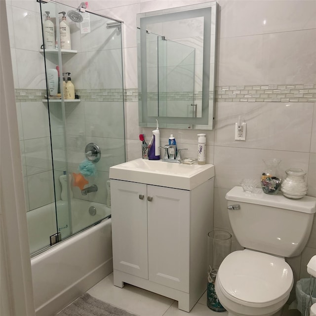 full bathroom with toilet, tile walls, enclosed tub / shower combo, and vanity