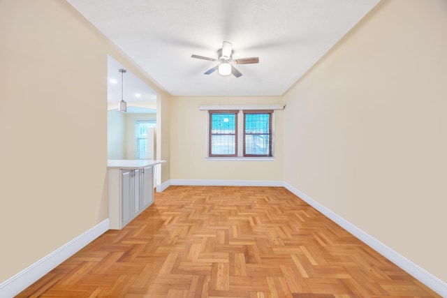 empty room with ceiling fan and light parquet floors