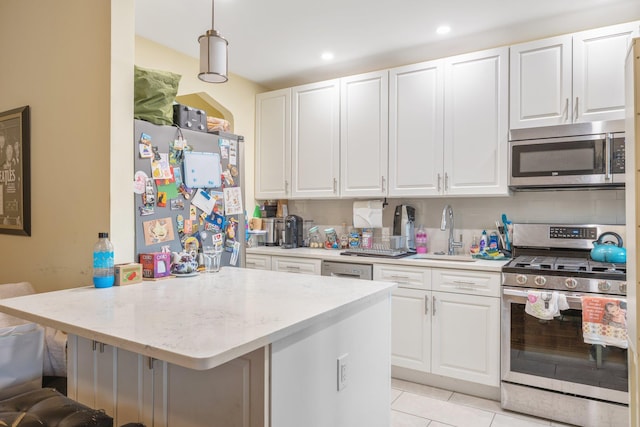 kitchen with appliances with stainless steel finishes, sink, a breakfast bar area, and white cabinets