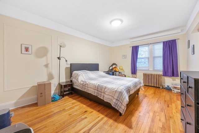 bedroom featuring radiator and light wood-type flooring