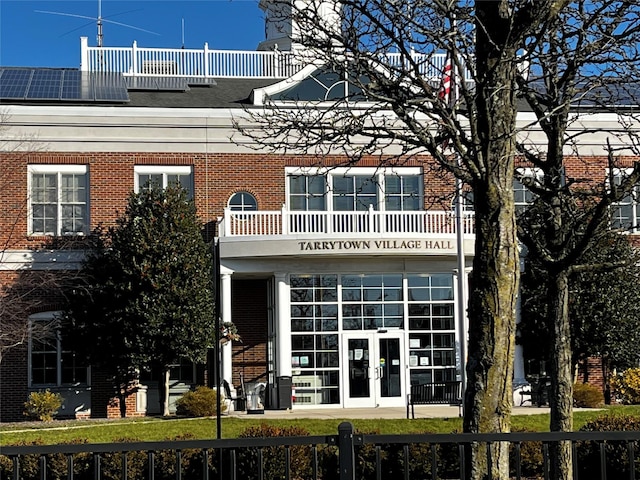 back of property featuring a balcony and french doors