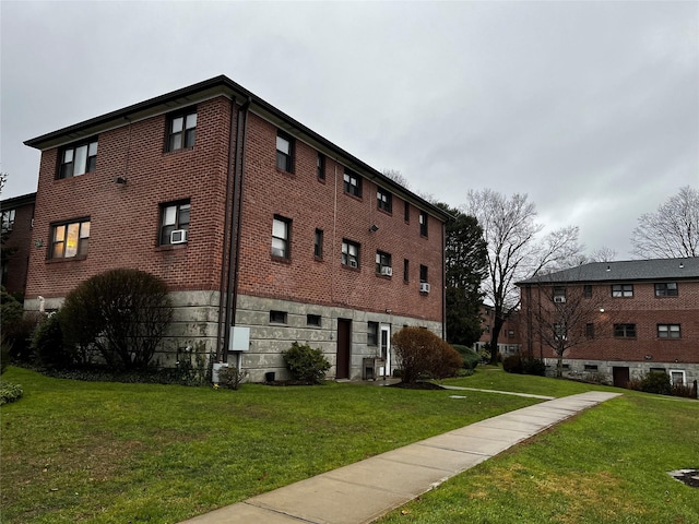 exterior space with brick siding and a lawn