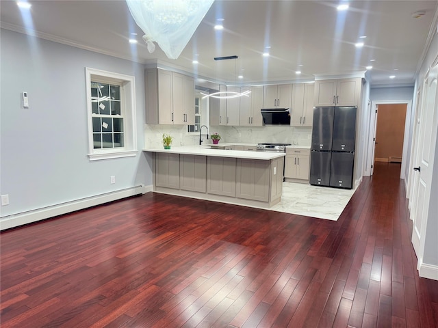 kitchen with extractor fan, kitchen peninsula, black refrigerator, hanging light fixtures, and crown molding