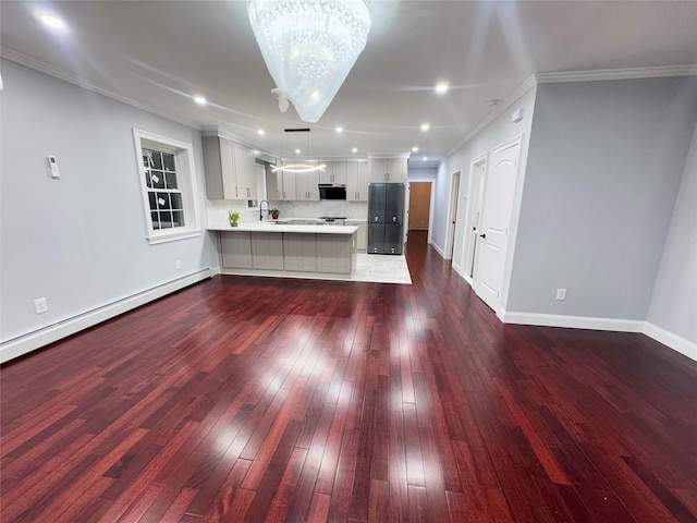 kitchen featuring kitchen peninsula, a chandelier, pendant lighting, white cabinets, and sink