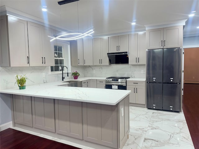 kitchen with black fridge, gas stove, kitchen peninsula, and gray cabinets