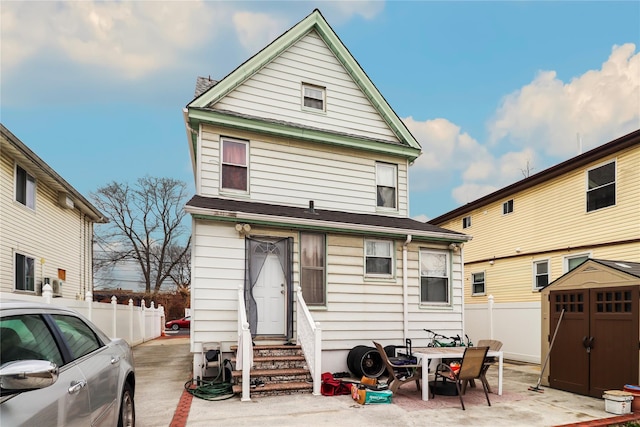 back of house featuring a storage unit and a patio