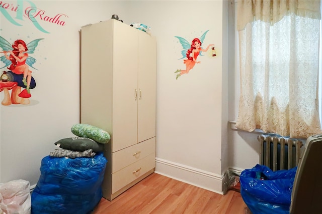 bedroom with radiator and light hardwood / wood-style flooring