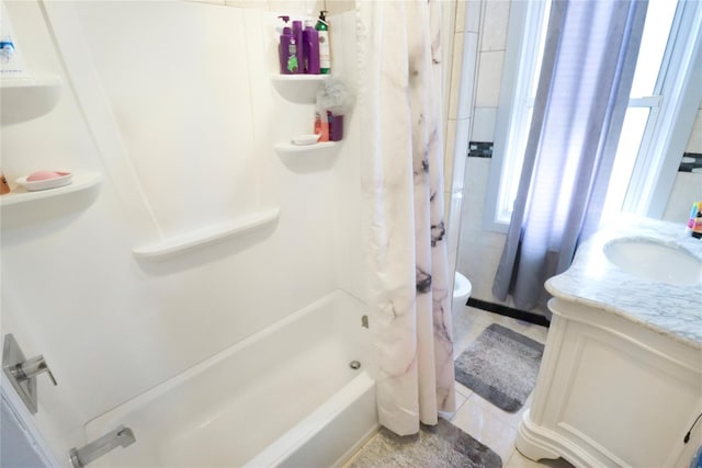 full bathroom featuring toilet, vanity, tile patterned floors, and shower / bath combo with shower curtain