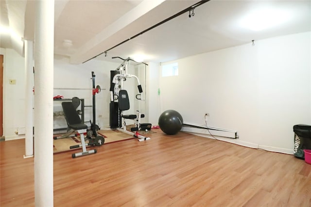 workout room with baseboard heating and light hardwood / wood-style flooring