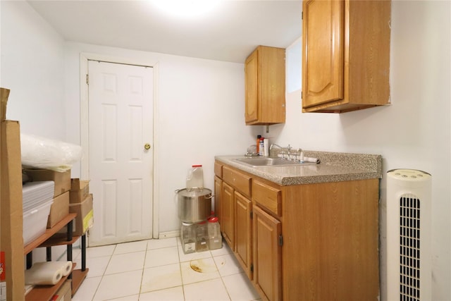 kitchen with heating unit, light tile patterned floors, and sink