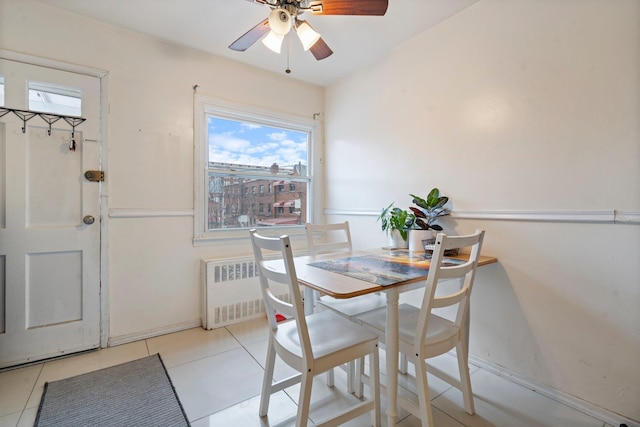 dining room with ceiling fan, radiator heating unit, and light tile patterned flooring