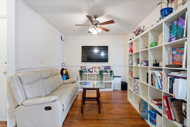 living room featuring ceiling fan and dark hardwood / wood-style floors