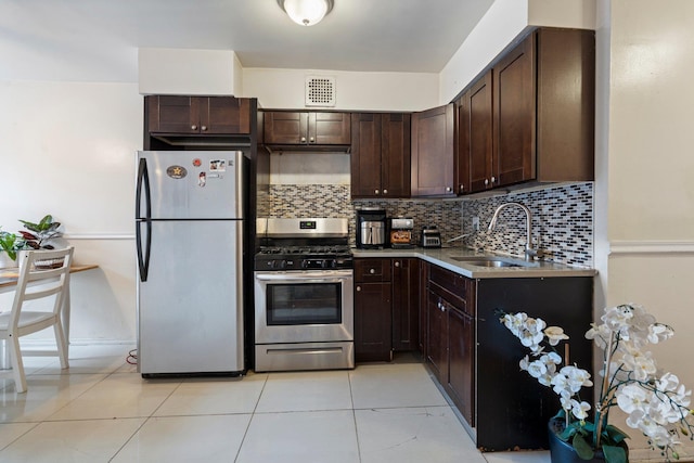 kitchen featuring light tile patterned floors, appliances with stainless steel finishes, tasteful backsplash, dark brown cabinetry, and sink