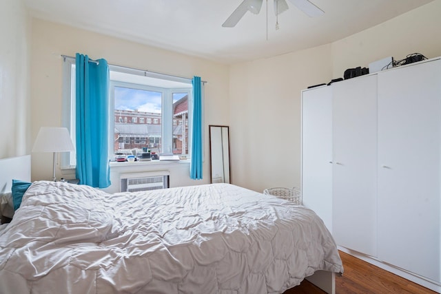 bedroom with ceiling fan, a wall mounted AC, and wood-type flooring