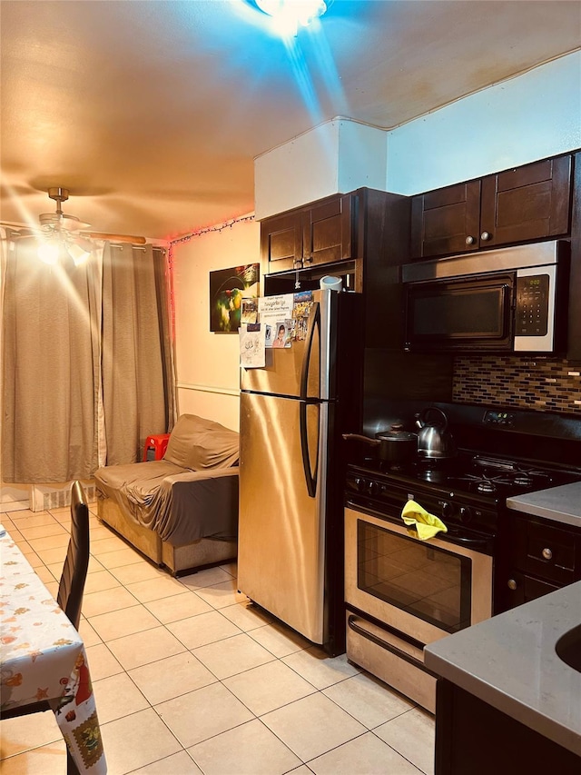 kitchen featuring light tile patterned floors, appliances with stainless steel finishes, dark brown cabinets, and backsplash