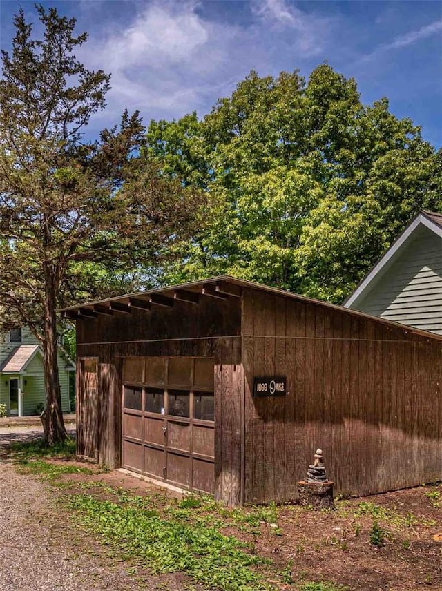 view of home's exterior with a garage and an outbuilding