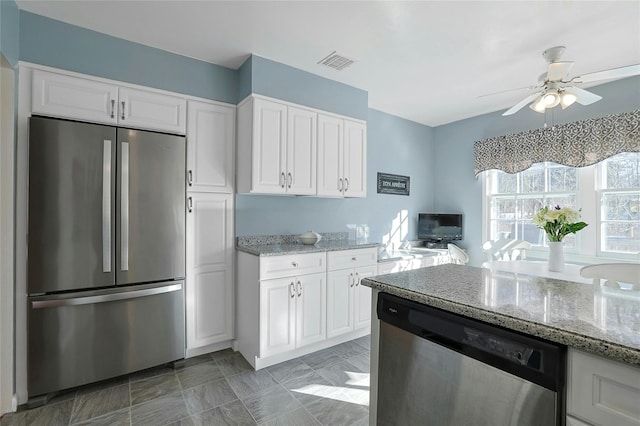 kitchen featuring appliances with stainless steel finishes, ceiling fan, light stone countertops, and white cabinets