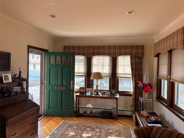 interior space featuring a baseboard heating unit, crown molding, and light hardwood / wood-style floors