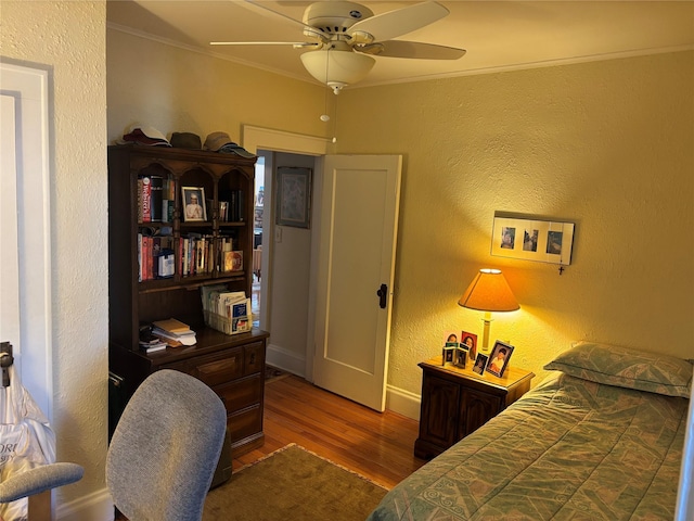 bedroom with crown molding, ceiling fan, and hardwood / wood-style flooring